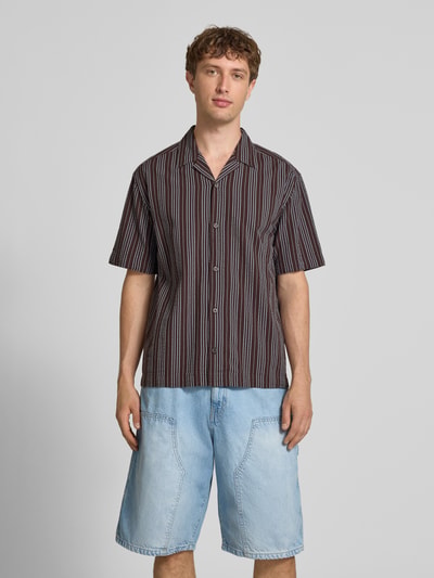 Männermodel trägt Relaxed Fit Freizeithemd aus reiner Baumwolle Modell 'CRUZ' von Only & Sons, gestreift, Resort-Kragen, Seersucker, Ganzkörperansicht von vorne.