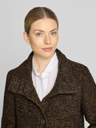 Vrouwenmodel draagt lange wollen jas van scheerwolmix model 'PAMELA' van Milo Coats, recht pasvorm, opstaande kraag, steekzakken, doorlopende knoopsluiting, mix van bruin en zwart, gestructureerde textuur, Nahaufnahme bovenlichaam. Ruglengte maat 36: 101 cm, schouderbreedte: 38 cm, borstwijdte: 50 cm, mouwlengte: 66 cm.