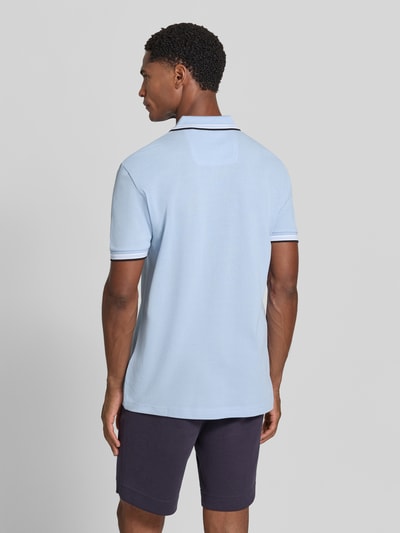 Männermodel trägt Regular Fit Poloshirt mit Label-Stitching Modell 'Paddy' von BOSS in Hellblau, reine Baumwolle, Ganzkörperansicht Rückansicht.