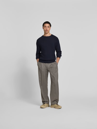 Männermodel trägt Regular Fit Pullover in Strick-Optik von Closed in Dunkelblau, Reine Baumwolle, Rundhalsausschnitt, Ganzkörperansicht von vorne.