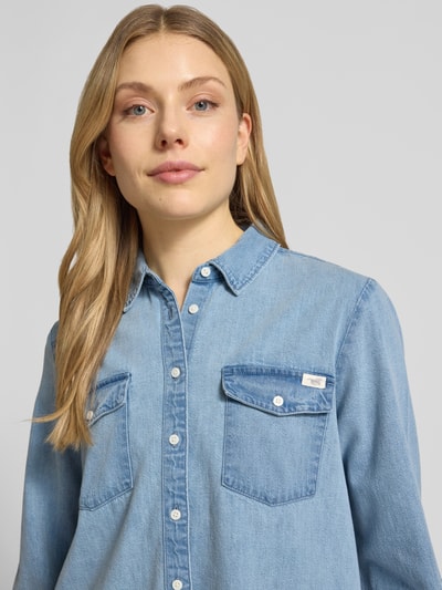 Vrouwenmodel draagt Regular Fit Jeanshemd met borstzakken model 'SEDANA' van Mustang, puur katoen, labeldetail, ruglengte maat 36: 63 cm, nahaufnahme bovenlichaam.