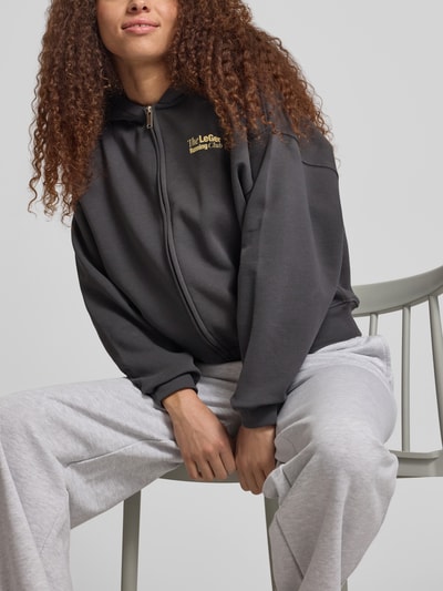 Frauenmodel trägt Oversized Sweatjacke mit Kapuze Modell 'Admira' von LeGer by Lena Gercke aus Baumwoll-Mix in Dunkelgrau mit Reißverschluss, Nahaufnahme Oberkörper.