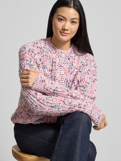 Frauenmodel trägt Strickjacke mit Knopfleiste Modell 'CONFETTI' von YAS, lockerer Schnitt, gerippte Abschlüsse, Rundhalsausschnitt, Pattentaschen, mehrfarbig melierte Textur, Ganzeansicht Oberkörper.