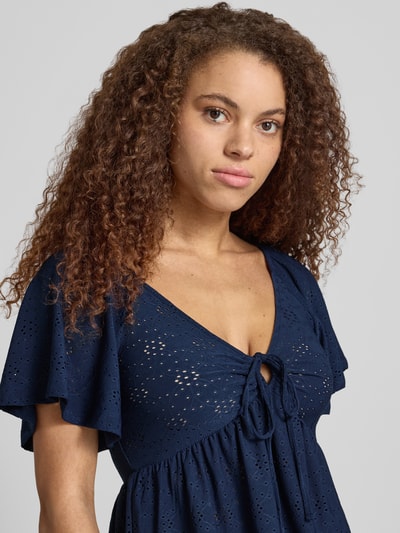 Frauenmodel trägt Slim Fit T-Shirt mit tiefem V-Ausschnitt Modell 'SMILLA' von Only, semitransparent, floral, Kurzarm, Stretch, Nahaufnahme Oberkörper.