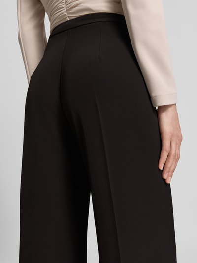 Frauenmodel trägt Stoffhose mit Bügelfalte von Rinascimento in Schwarz, Material-Mix mit Stretch, Wide Leg Fit, Detailaufnahme Rückansicht.