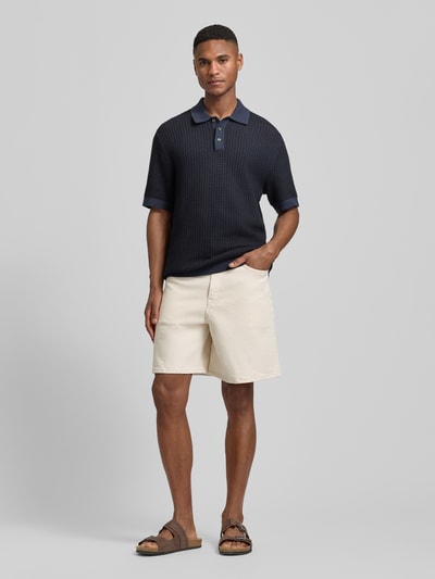 Männermodel trägt Relaxed Fit Jeansshorts aus Baumwoll-Mix Modell 'LOOSE ALEX SUMMER' von SELECTED HOMME in Beige, 5-Pocket-Design, Ganzkörperansicht von vorne.