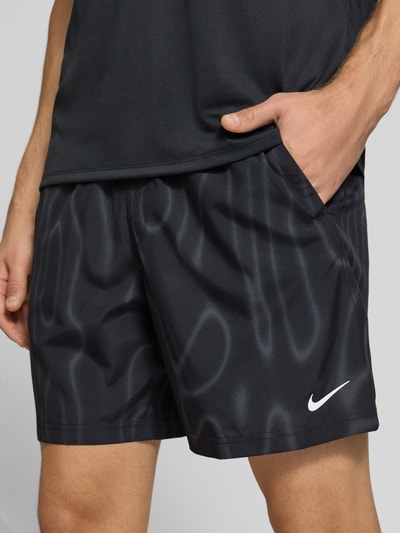 Männermodel trägt Regular Fit Sportshorts mit Dri-FIT-Technologie von Nike, dunkle Farbe, glatte Textur, Nahaufnahme Oberschenkel, Herren Sportshorts von Nike Training.