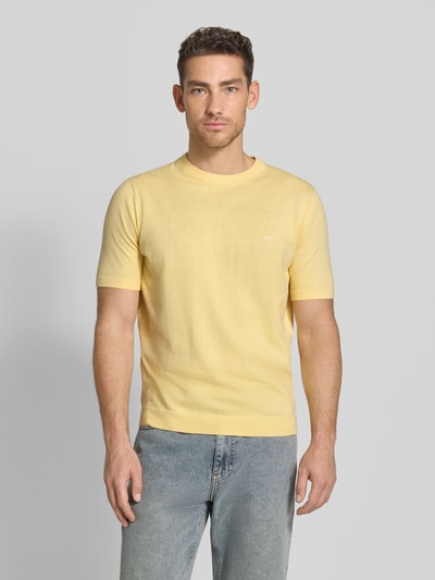 Mannenmodel draagt Regular Fit T-Shirt mit Leinen-Anteil in Strick-Optik van Fynch-Hatton in lichtgeel, katoenmix met linnen, gemêleerd oppervlak, logo-stiksel, elastische boorden, ruglengte maat M 70 cm, frontale lichaamsopname.