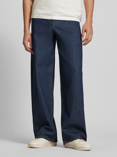 Männermodel trägt Wide Fit Jeans im 5-Pockets-Design Modell 'Dave' von Jack & Jones in Dunkelblau, reine Baumwolle, Ganzkörperansicht von vorne.