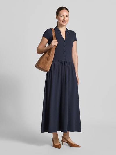 Frauenmodel trägt Midikleid aus Viskose-Mix von Emporio Armani in Dunkelblau mit Umlegekragen und Knopfleiste, Ganzkörperansicht von vorne. Taillierte Passform, kurzärmeliges Design mit Stretch-Anteil, Rückenlänge 125 cm, Brustweite 43 cm, Ärmellänge 11 cm.