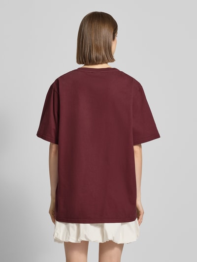 Frauenmodel trägt Oversized T-Shirt mit Statement-Print von OH APRIL, Reine Baumwolle, Oversized-Fit, Rückenlänge 70 cm, Ganzkörperansicht Rückansicht.