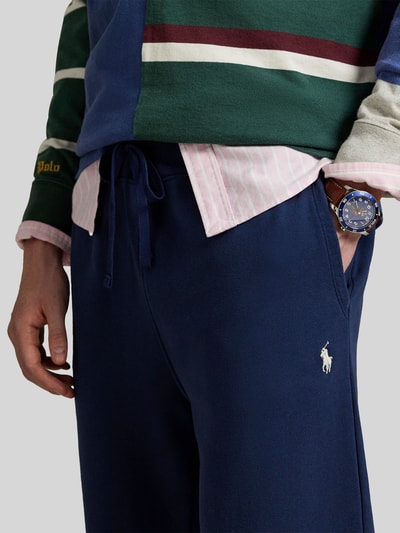 Männermodel trägt Regular Fit Sweatpants aus reiner Baumwolle von Polo Ralph Lauren in Dunkelblau mit Logo-Stitching, Nahaufnahme Oberkörper.