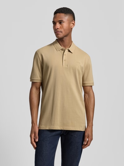 Männermodel trägt Regular Fit Poloshirt aus reiner Baumwolle Modell 'DONOS222' von HUGO in Beige mit Polokragen, Ganzkörperansicht von vorne.