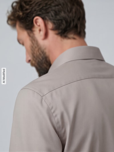 Männermodel trägt Slimf Fit Businesshemd aus reiner Baumwolle Modell 'New Kent' von Seidensticker in hellem Beige, glatte Textur, Ganzkörperansicht Rückansicht. Herren Businesshemd von Seidensticker.