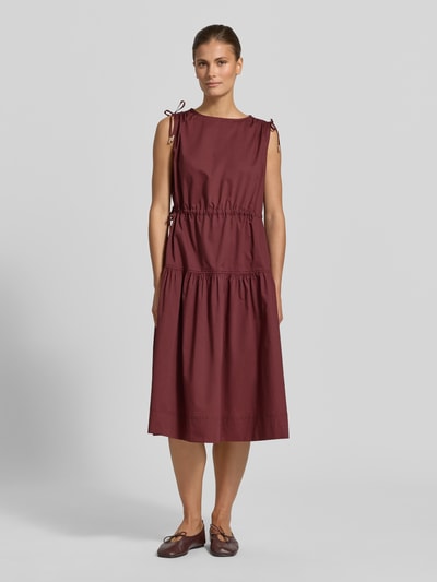 Frauenmodel trägt Midikleid im Stufen-Look mit Rundhalsausschnitt von Christian Berg Woman, Reine Baumwolle, A-Linie, Ganzkörperansicht von vorne. Rückenlänge bei Größe 36: 110 cm, Brustweite bei Größe 36: 52 cm. Warmer Bordeauxton, glatte Textur.