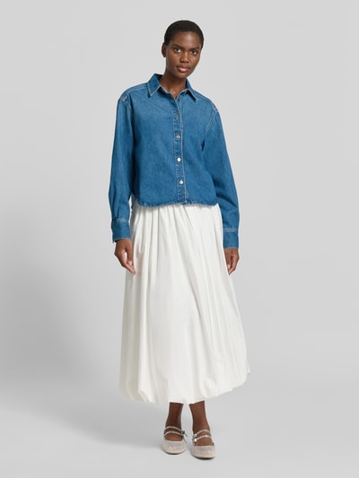 Frauenmodel trägt Relaxed Fit Jeansbluse mit Knopfleiste Modell 'CELIA' von Samsøe Samsøe aus reiner Baumwolle, Ganzkörperansicht von vorne.