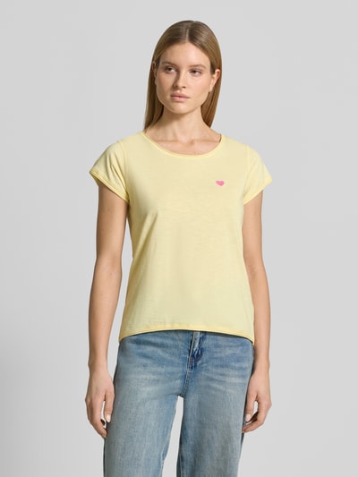 Frauenmodel trägt T-Shirt mit Stitching und Rundhalsausschnitt von Christian Berg Woman in Hellgelb, reine Baumwolle, Regular Fit, Rollsaum, Ganzkörperansicht von vorne.