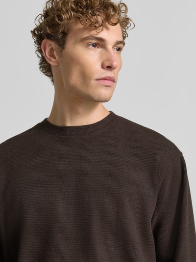 Mannelijk model draagt pullover met ronde hals Model 'KARIO' van DRYKORN in bruin Materiaalmix katoen, los model, detailopname bovenlichaam.