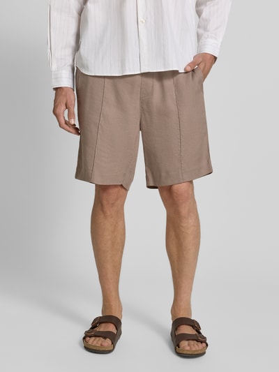 Męski model nosi Straight Fit Chinoshorts aus Leinen-Lyocell-Mix Modell 'CINO' von HUGO, efekt: jednolity kolor, wpuszczane kieszenie, tunel, elastyczny ściągacz, wykończenie: cieniowana przędza, materiał: mieszanka lnu i lyocellu, ganzkörperansicht von vorne.