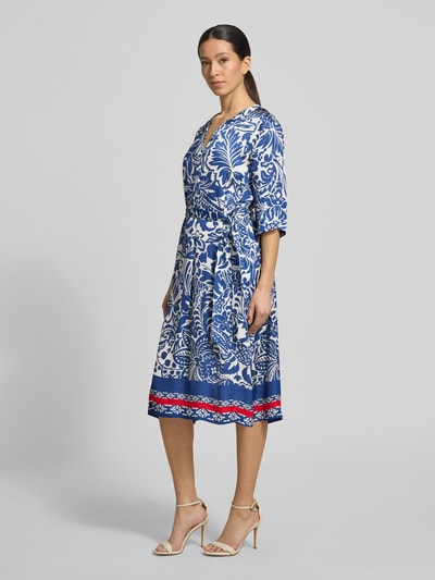 Frauenmodel trägt Tunikakleid aus Viskose mit Bindegürtel von WHITE LABEL, blauer Allover-Look, taillierter Schnitt, Midikleid, Ganzkörperansicht von vorne. Rückenlänge 113 cm, Brustweite 54 cm, Ärmellänge 36 cm.