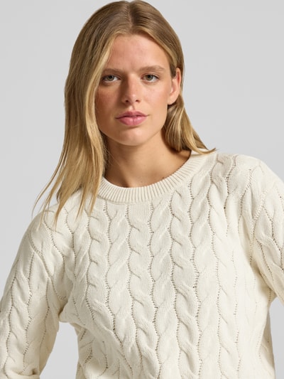 Frauenmodel trägt Strickpullover mit Zopfmuster Modell 'DARIELLA' von NOISY MAY, cremefarben, Baumwoll-Mix, Nahaufnahme Oberkörper.