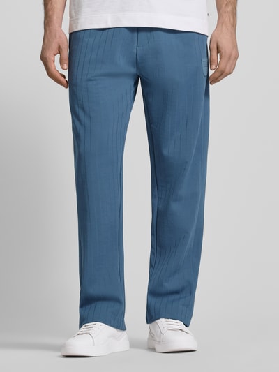 Männermodel trägt Regular Fit Sweatpants aus Baumwoll-Mix Modell 'DAVROPANT' von HUGO, Optik: Unifarben, Muster: gestreift, Label-Patch, Tunnelzug, elastischer Bundabschluss, seitliche Eingrifftaschen, Sweat Materialverarbeitung, Beinabschluss mit Seitenschlitz und Reißverschluss, Ganzkörperansicht von vorne.