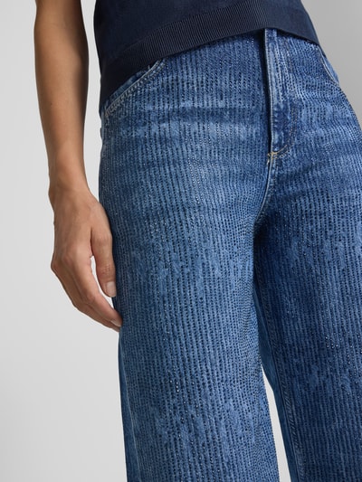 Vrouwenmodel draagt Straight Fit Jeans uit puur lyocell van Liu Jo White met all-over strass-steentjes en 5-pocketmodel, detailopname bovenbeen.