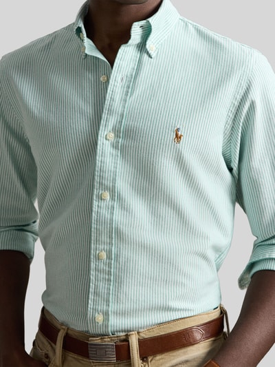 Männermodel trägt Custom Fit Freizeithemd aus reiner Baumwolle von Polo Ralph Lauren, hellgrün-weiß gestreift, Knopfleiste, Nahaufnahme Oberkörper.