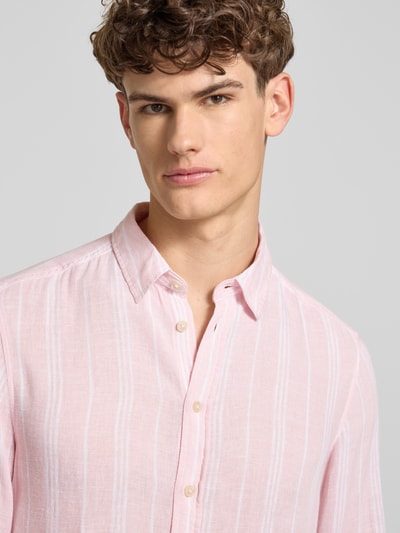 Männermodel trägt Regular Fit Leinenhemd mit Viskose-Anteil Modell 'Bobby' von Blend, Kentkragen, Hellrosa mit feinen Streifen, Nahaufnahme Oberkörper.