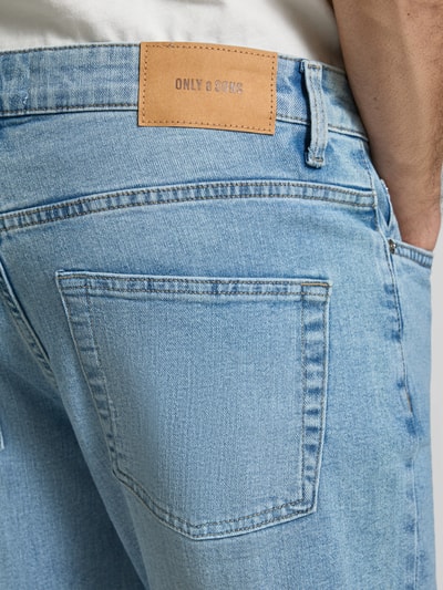 Männermodel trägt Regular Fit Jeans aus Baumwoll-Mix Modell 'WEFT' von Only & Sons in Hellblau mit Label Patch, Nahaufnahme Rückansicht.