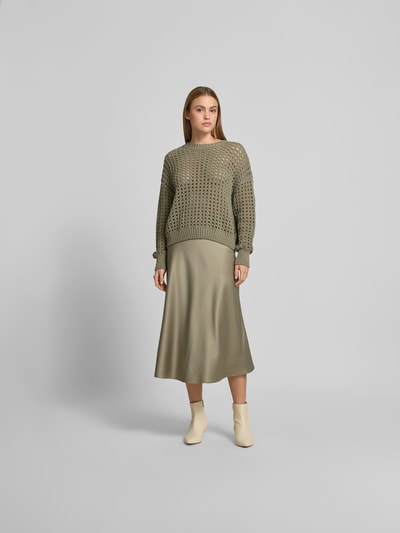 Frauenmodel trägt Midirock aus Satin mit Reißverschluss von Juvia, schmale Passform, Midi-Länge, olivgrün mit glatter Satin-Optik, Ganzkörperansicht von vorne.