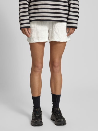 Frauenmodel trägt Relaxed Fit Shorts aus reiner Baumwolle Modell 'THYRA' von Only in Optik: Unifarben, Crêpe Materialverarbeitung, Bundabschluss: Elastisch, seitliche Eingrifftaschen, Ganzkörperansicht von vorne.