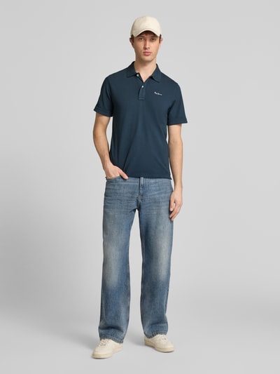 Männermodel trägt Regular Fit Poloshirt aus reiner Baumwolle Modell 'OSCAR' von Pepe Jeans, efekt: jednolity kolor, wyhaftowane logo, krój regular fit, kołnierzyk polo, dekolt w serek, listwa guzikowa, krótki rękaw, prążkowane zakończenie rękawów, wykończenie z rozcięciem po bokach, wykończenie materiału: pika, bawełna, Ganzkörperansicht von vorne