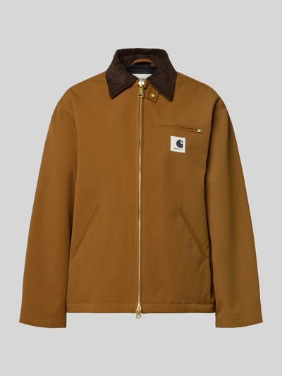 Produktfoto, kurtka Jacke mit Stehkragen und Zweiwege-Reißverschluss Modell 'Clark' od Carhartt Work In Progress w kolorze brązowym, detal z logo, krój relaxed fit, stójka, długość tyłu w rozmiarze S 66 cm, szerokość ramion w rozmiarze S 50 cm, szerokość w rozmiarze S 54 cm, długość rękawów w rozmiarze S 58 cm