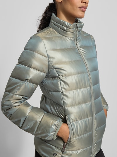 Kobieta nosi Jacke mit Kapuze od NAUTGÅRD, luźny krój, kaptur, tunel, ukryty zamek, detal z logo, pasek na rękaw, zbliżenie górnej części ciała.