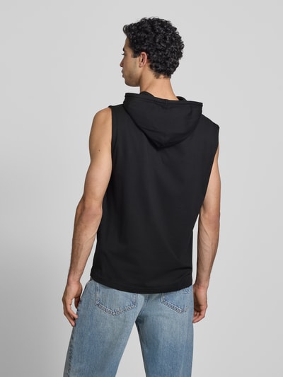 Männermodel trägt Hoodie mit Label-Stitching von CHAMPION in Schwarz, reine Baumwolle, ärmellos, Regular Fit, Ganzkörperansicht Rückansicht.