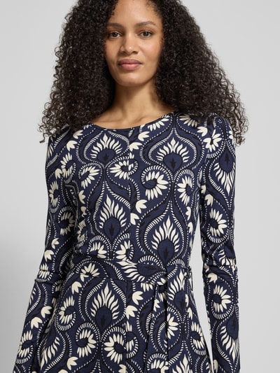 Kobiece modelka nosi tailliertes Freizeitkleid aus Viskose-Mix Modell 'SAVANA' od Weekend Max Mara, granatowy z białym wzorem, krój taliowany, materiał jersey, długi rękaw, długość midi, okrągły dekolt, pasek w talii, całopowierzchniowy wzór, widok na górną część ciała z przodu.