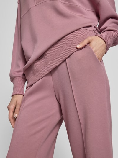 Frauenmodel trägt Wide-Leg-Pants mit französischen Eingrifftaschen von VARLEY aus Viskose-Mix mit Stretch-Anteil, Nahaufnahme Oberkörper.