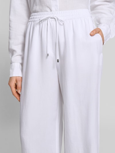 Frauenmodel trägt Loose Fit Leinenhose aus Lyocell-Leinen-Mix Modell 'TAVATI2_TI' von BOSS, Optik: Unifarben, Passform: Loose-Fit, Label-Applikation aus Metall, Tunnelzug, Bundabschluss: elastisch, seitliche Eingrifftaschen, Material: Lyocell-Leinen-Mix, Nahaufnahme Oberkörper.