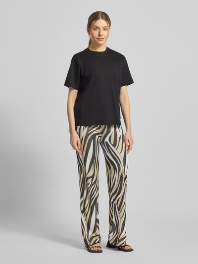 Frauenmodel trägt Hose aus Viskose im Allover-Look von Marella, Wide Leg, elastischer Bund, Muster in Beige, Schwarz, Weiß, Ganzkörperansicht von vorne.