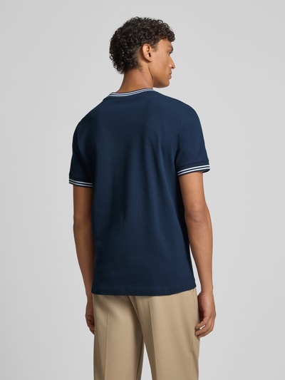 Männermodel trägt dunkelblaues Herren T-Shirt mit weißen Kontraststreifen Modell 'Jose' von JOOP! Collection, Baumwoll-Elasthan-Mix, Regular-Fit, Rundhalsausschnitt, Rückenlänge bei Größe M 67 cm, Ganzkörperansicht Rückansicht.
