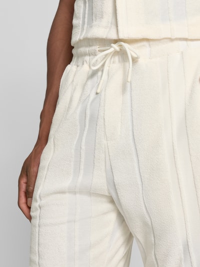 Männermodel trägt Relaxed Fit Shorts aus katoenmix van Tom Tailor, heren sweatshorts, crèmekleur, verticale structuur, detailaufnahme linkerzij.
