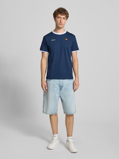 Mannenmodel draagt t-shirt im Retro-Look Model 'RINGETTO' van ellesse, puur katoen, regular fit, ronde hals, ruglengte maat M 70 cm, ganzlichaamsvooraanzicht.