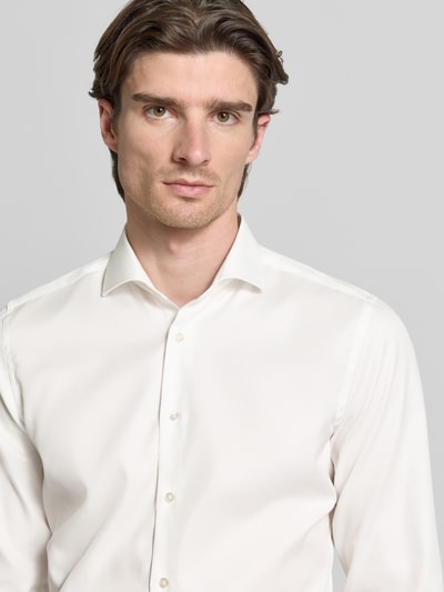 Männermodel trägt Slim Fit Businesshemd aus Twill von Eterna in Weiß mit Haifischkragen, Knopfleiste, feiner Webstruktur, Nahaufnahme Oberkörper.
