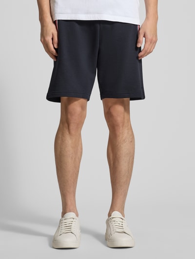 Männermodel trägt Shorts mit elastischem Bund von Christian Berg Men in Dunkelblau, Regular Fit, Baumwoll-Elasthan-Mix, Ganzkörperansicht von vorne.