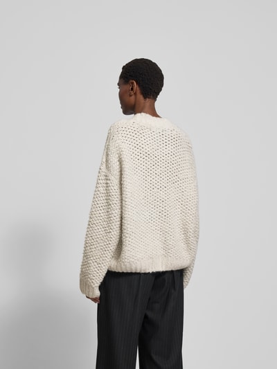 Frauenmodel trägt Pullover mit gerippten Abschlüssen von black palms, Alpaka-Woll-Mix, Oversized, cremefarben, Rückenlänge 65 cm, Ganzkörperansicht Rückansicht.