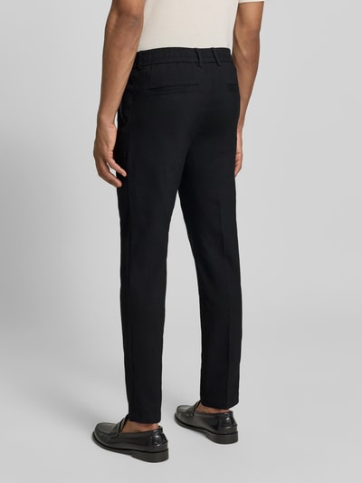 Männermodel trägt Modern Fit Straight Leg Hose aus Leinen-Mix Modell 'KANE1' von BOSS in Schwarz, unifarben, Ganzkörperansicht Rückansicht.