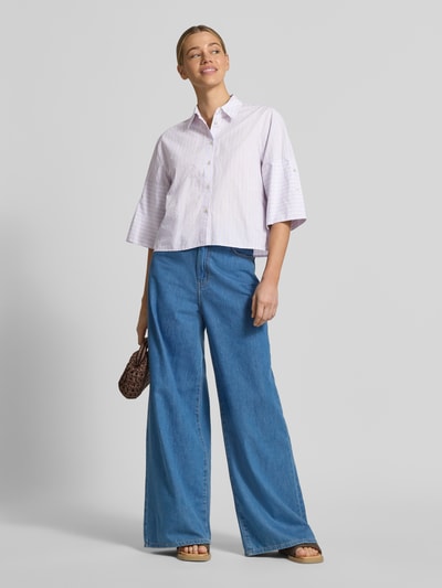Frauenmodel trägt Relaxed Fit Hemdbluse mit Hemdblusenkragen von Emily Van den Bergh aus Reine Baumwolle, 3/4-Arm, Knopfleiste, Ganzkörperansicht von vorne.