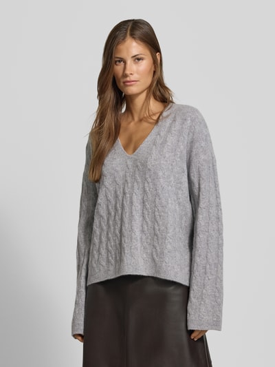 Frauenmodel trägt Relaxed Fit Pullover aus reiner Baumwolle von MYON, grau, Strick-Optik, V-Ausschnitt, Ganzkörperansicht von vorne