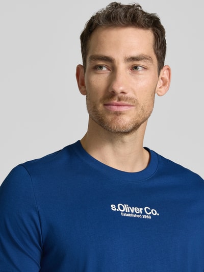 Männermodel draagt Regular Fit T-shirt aus reiner Baumwolle van s.Oliver RED LABEL, look: effen, labelprint, ronde hals, korte mouw, puur katoen. Nahaufnahme bovenlichaam.